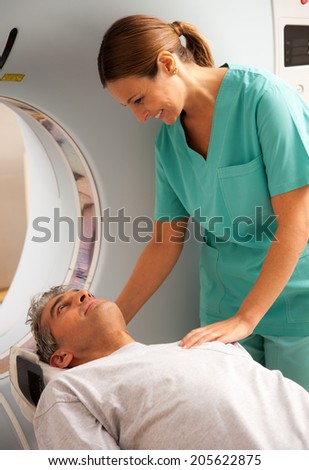 Young female doctor reassuring man undergoing mri scan.
