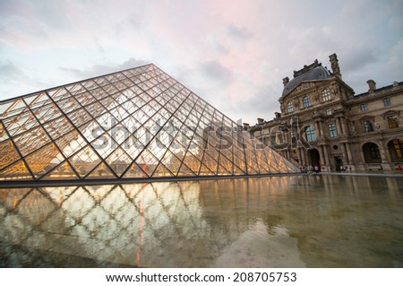 PARIS - JUNE 19: The Louvre museum and the pyramid on June 19, 2014 in Paris, France. The Louvre was once a palace and is now a museum. The pyramid serves as an entrance to the museum
