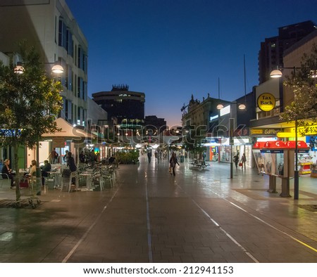 SYDNEY - JULY 21, 2010: Tourists walk along city streets at night. The city attracts more than 10 million people every year.
