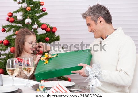 Child receiving gift from dad. Christmas concept.