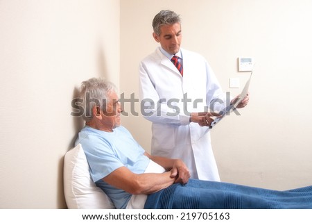 Male doctor explaining medical test to happy elder patient.