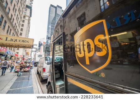 NEW YORK CITY  - MAY 13, 2013: The ups-logo on a UPS van in the streets of New York, people walking by in the reflection of the van