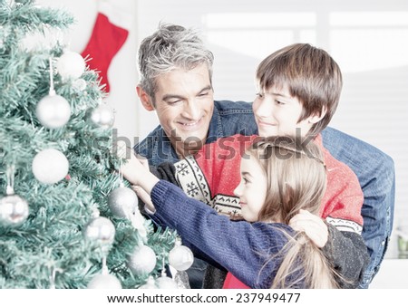 Father with son and daughter decorating Christmas tree. Family Christmas concept.