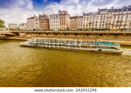 PARIS - JUNE 19, 2014: Bateau Mouche on the river. Bateaux Mouches are open excursion boats that provide visitors with a view of the city from along Seine.