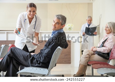 Doctors and patients speaking in the hospital waiting room.