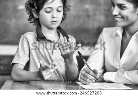 Hand of kid learning math with teacher.