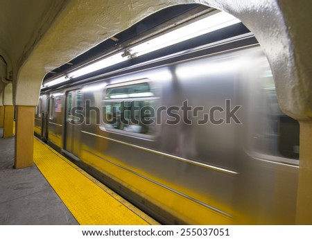 Train speeding up in New York City subway station.