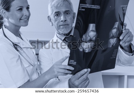 Expert doctor analyzing x-ray scan with female assistant.