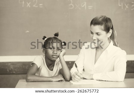 Happy female teacher comforting sad afroamerican schoolgirl.