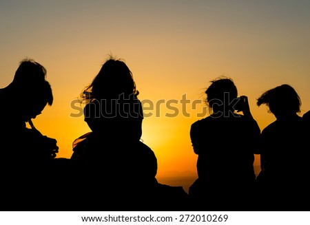 Tourist watching sunset. Silhouettes against golden hour sky.