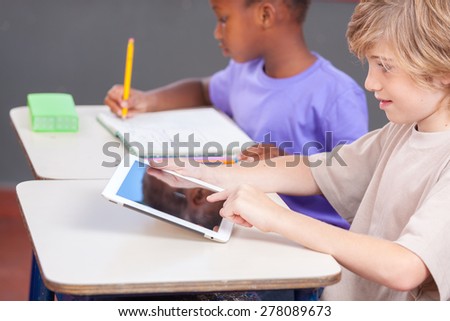 Caucasian boy and afro american girl at school with tablet and book.