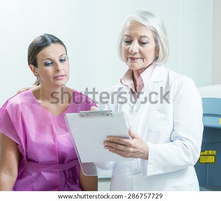Expert female doctor explaing medical test to female patient in 40s.