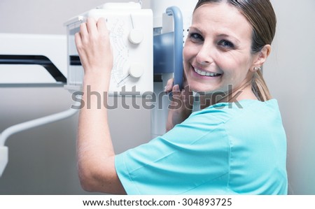 Female doctor setting up medical machine.