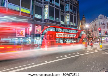 LONDON - JUNE 14, 2015: Red Double Decker Bus speeds up in city streets at night. These modern buses came to replace an old classic,the AEC Routemaster.