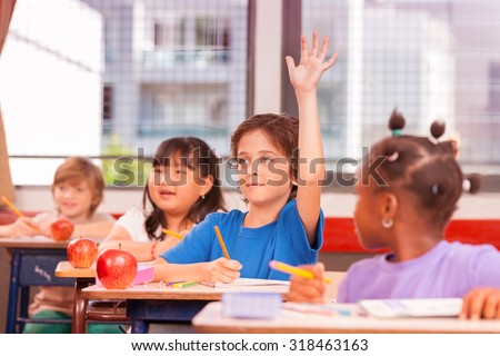 Kid raising hand in elementary school.