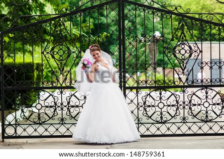 Young and beautiful bride in a white dress with a bouquet in hand
