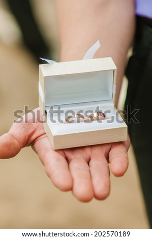 box with wedding rings in hands of the groom