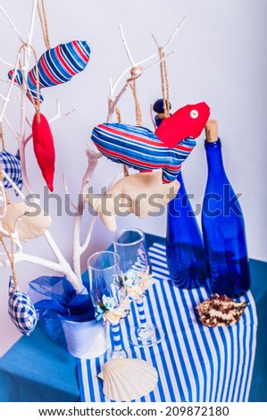 Decoration on the marine theme with seashells, fish, bottles and glasses