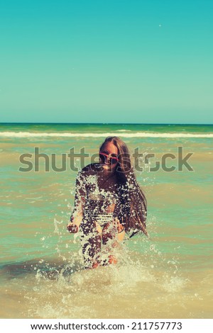 Young girl in the sea water splashes and smiling summer