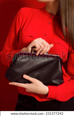 Beautiful girl with a black clutch bag in her hands