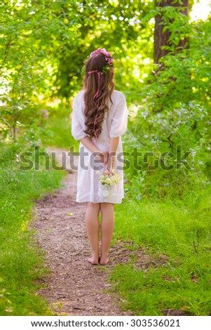 Girl with long hair in a forest with daisies