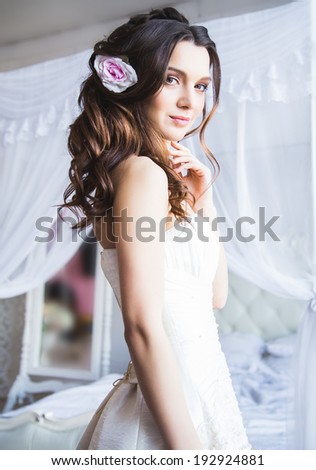 Portrait of beautiful bride model with perfect makeup and hair style in light room in a morning