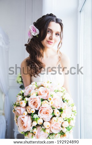 Portrait of beautiful bride model with perfect makeup and hair style in light room in a morning