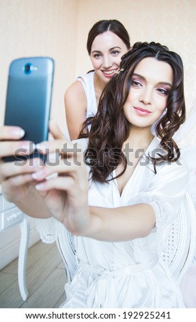 bride model making photo of herself and hair Stylist by mobile phone