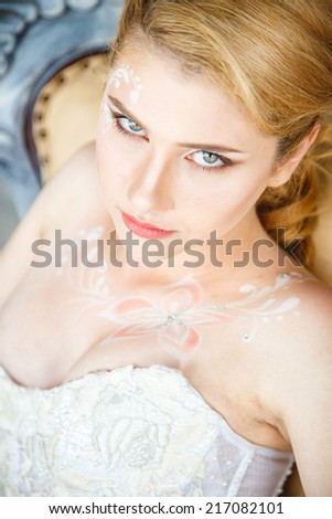 Beautiful blonde bride with perfect makeup and hair style in elegant interior