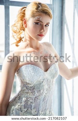 Beautiful blonde bride with perfect makeup and hair style in elegant interior