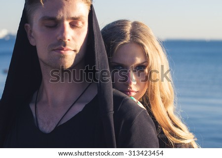 Beautiful couple violinist and young woman together near sea bay