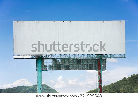 roadside billboard advertising display with blue sky and mountains