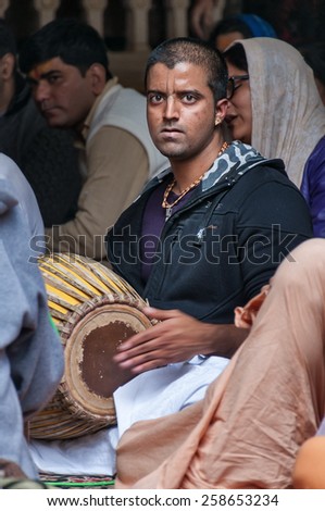 VRINDAVAN, INDIA - DEC 15, 2014:  Hare Krishna playing on drum in Sri Krishna-Balaram Temple. Vrindavan is considered to be a holy place. The major tradition followed in the area is Vaisnavism