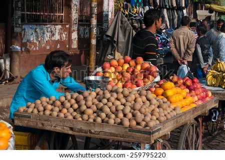AGRA, INDIA - DEC 16, 2014: An unidentified Indian vendor with fruit in market. Agra is major tourist destination because of its many splendid Mughal-era buildings, most notably Taj Mahal, Agra Fort