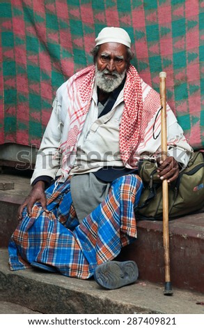 BANGALORE, INDIA - DEC 25, 2014:  Unidentified Indian elderly man sitting on step at Russell Market. Russell Market is a shopping market in Bangalore, built in 1927 by the British.