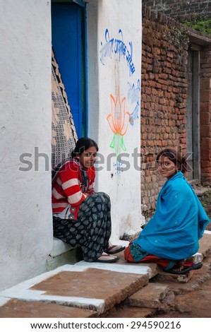 KHAJURAHO, INDIA - DEC 21, 2014: Unidentified Indian young women sit and chat on a house porch. Khajuraho is small town with  Khajuraho Group of Monuments located in the Indian state of Madhya Pradesh