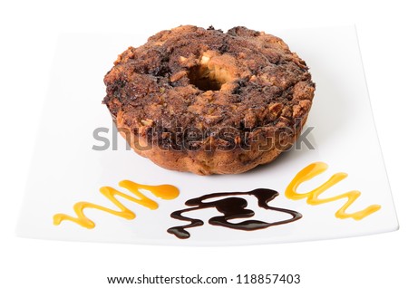 Apple coffee cake on a platter with swirls of chocolate and caramel, isolated on a white background