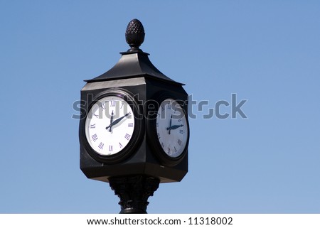 An outdoor clock telling the time, shot against a blue sky