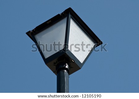Close up view of a lamp post shot against a cloudless blue sky