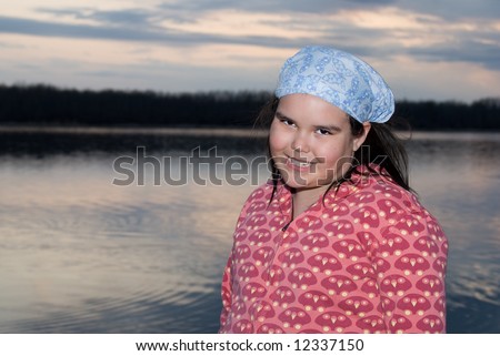 A young girl getting her portrait done in front of a lake