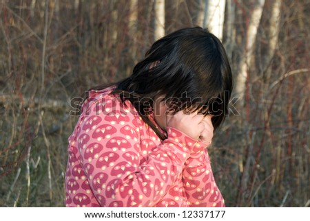 A young girl crying because she is lost in the woods