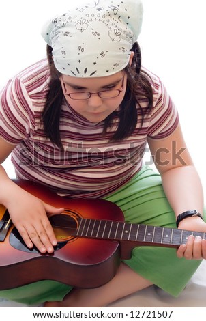 A cute child tapping a beat on an acoustic guitar