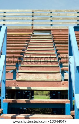 A low angle view of a set of stairs climbing up some school bleachers
