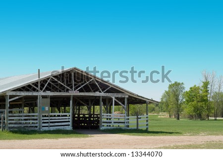 An empty cattle barn outside on a sunny day