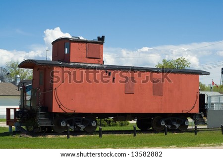 A red train caboose sitting on some railroad tracks outside