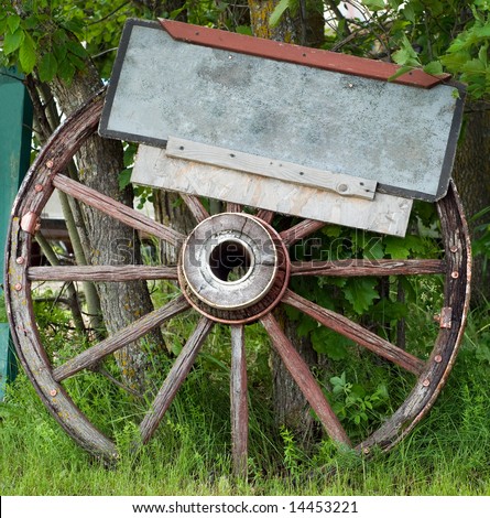 Close-up view of a wagon wheel with a blank sign attached, perfect for your text