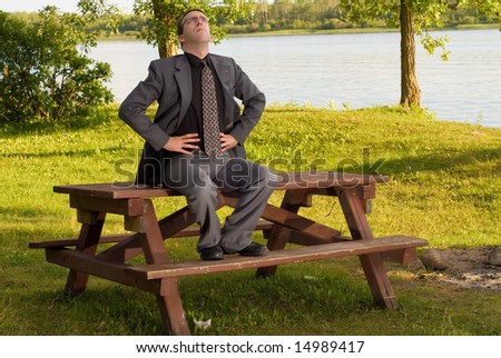 A young businessman wearing a grey suit doing deep breathing exercises