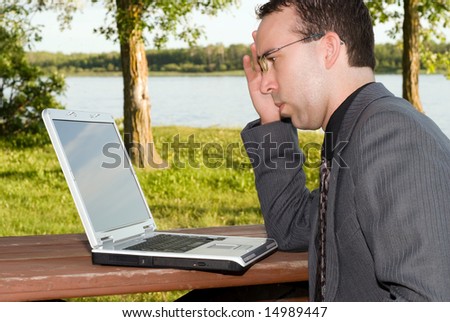 A young businessman working on his laptop outside