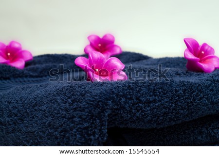 Four flowered candles on a blue towel used for aroma therapy