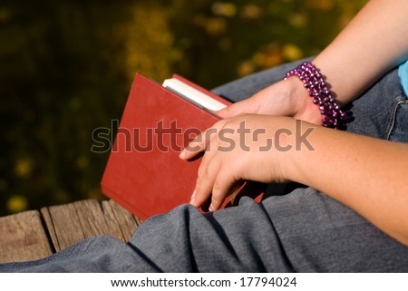 Closeup of a book and a girls leg, symbolizing quiet and relaxation